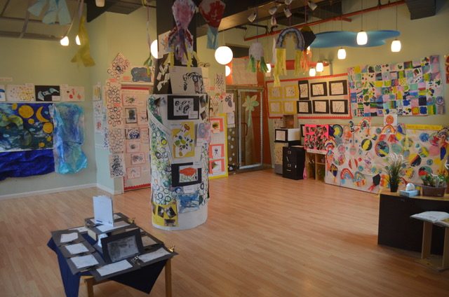 Art Gallery for preschoolers Art gallery with colorful artwork on walls and display tables, bright lighting.